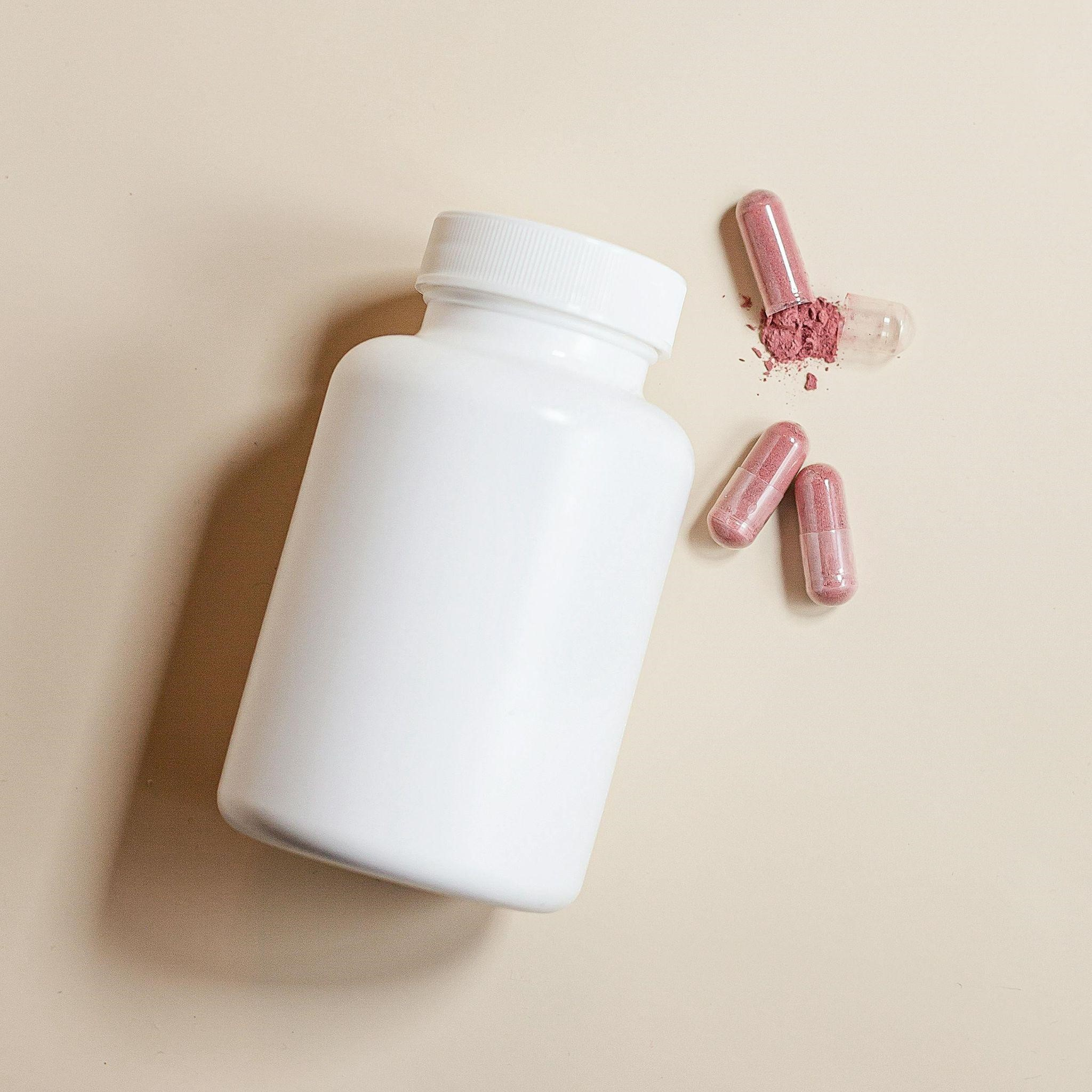4 Cara Mudah Memilih Suplemen yang Aman dan Terpercaya blogs - white color vitamin bottles with 3 capsules outside of the bottle